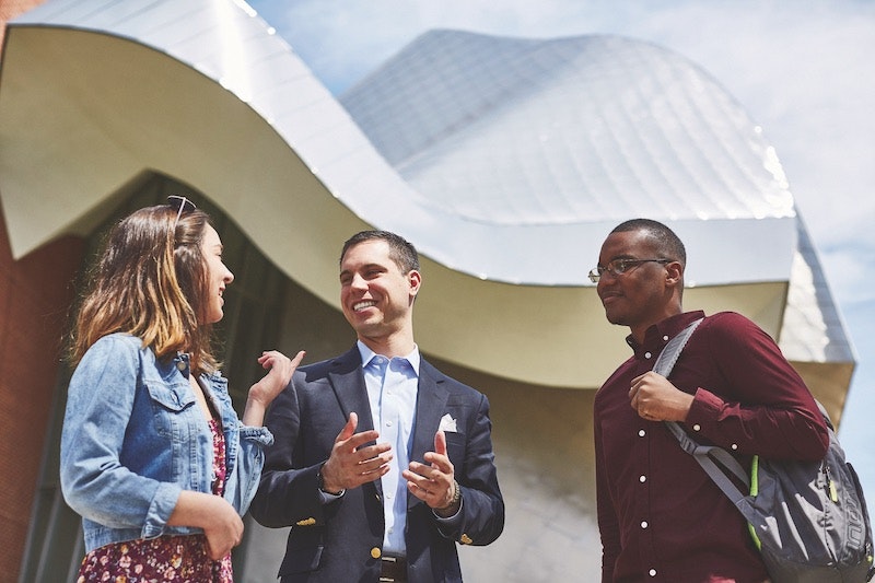 Three Case Western Reserve University graduate students speaking outside the Weatherhead School of Management