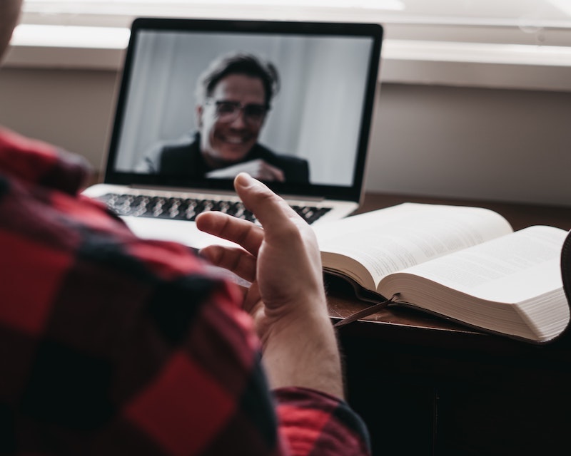 Online graduate student video conferencing with student success coach on laptop