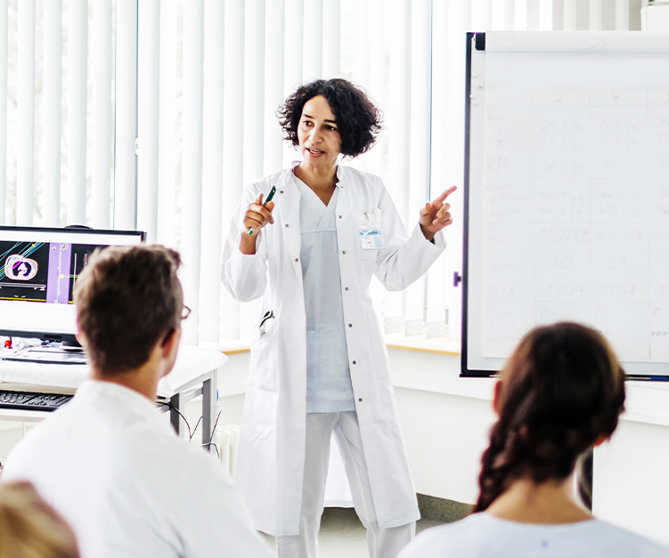 Physician presenting in front of a group of people.