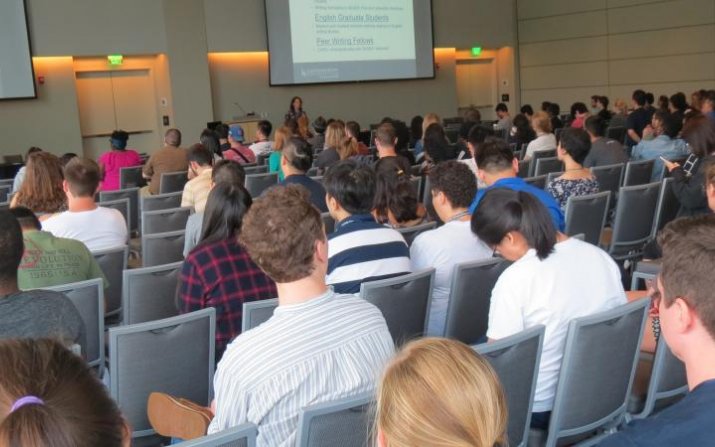 A group of students sit in a lecture hall.